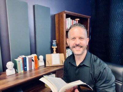 A man holding a book and smiling