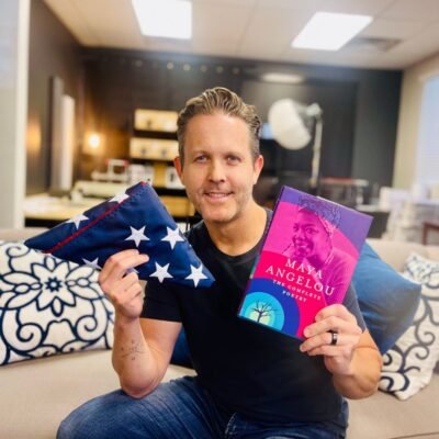 Eddy Hood with an American Flag an a copy of Maya Angelou s book The Complete Poetry