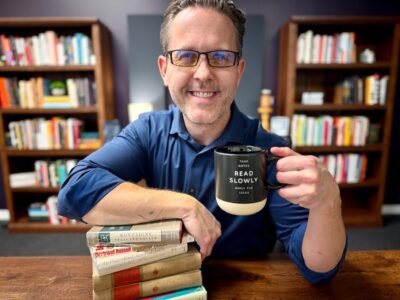 Eddy Hood with a stack of books and a coffee mug