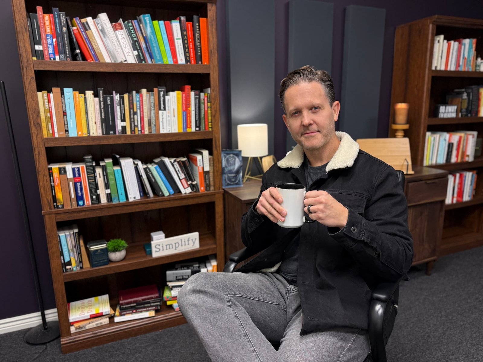 Eddy Hood in his reading room holding a cup of coffee.